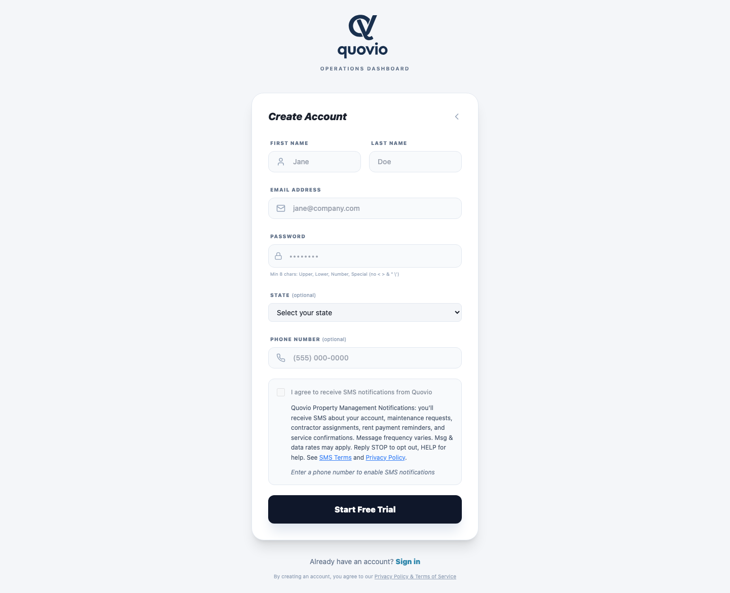 Quovio PM registration page at app.quovio.ai/register on desktop. Phone field is empty; the SMS consent checkbox is rendered disabled with helper text 'Enter a phone number to enable SMS notifications'. Full TCPA disclosure including program name, frequency, 'Msg & data rates may apply', STOP/HELP keywords, and links to SMS Terms and Privacy Policy is visible on page load.