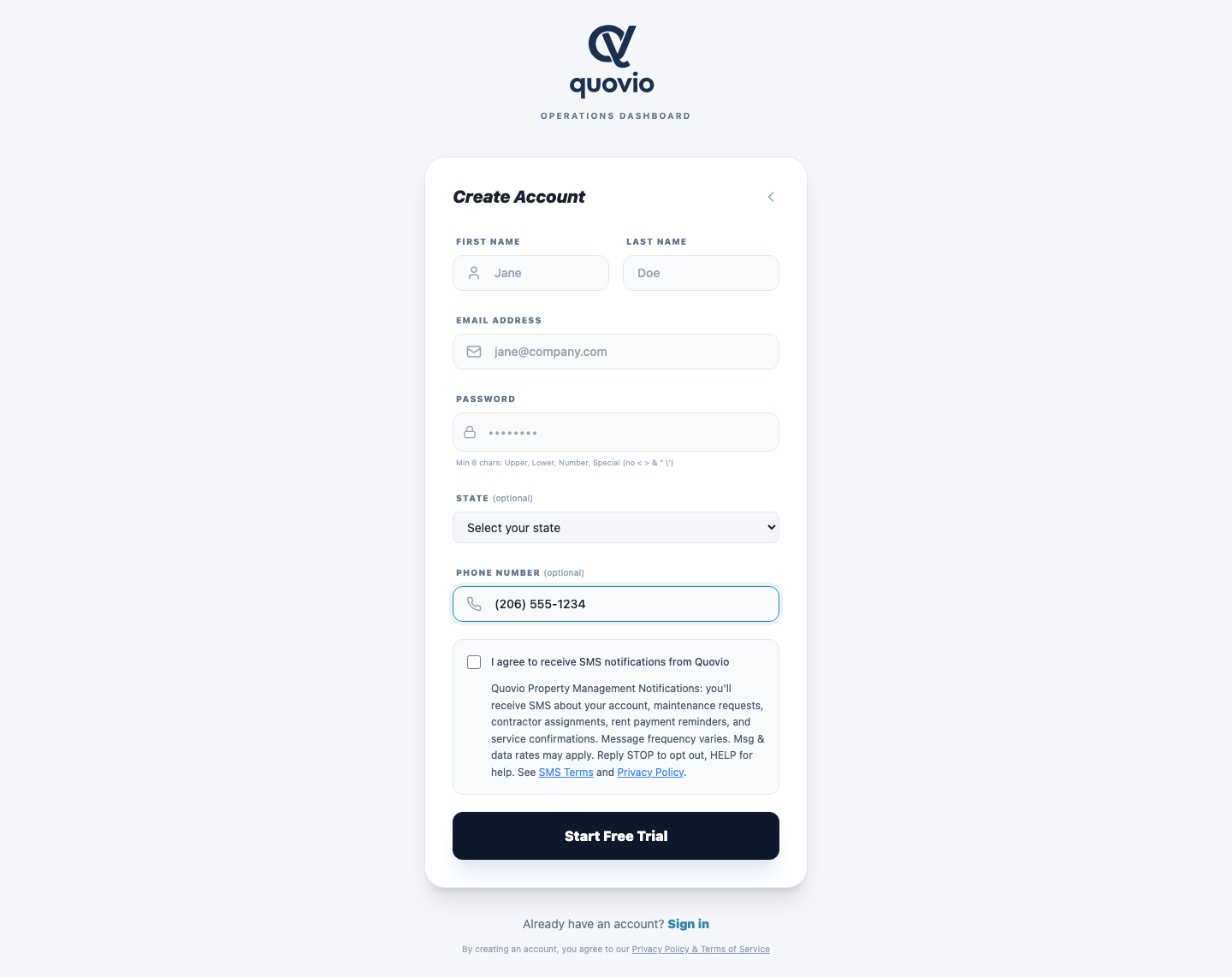 Quovio PM registration page at app.quovio.ai/register on desktop. Phone field contains (206) 555-1234. The SMS consent checkbox is now enabled (the 'Enter a phone number' helper text is gone). The checkbox is still unchecked — the user must affirmatively click it.